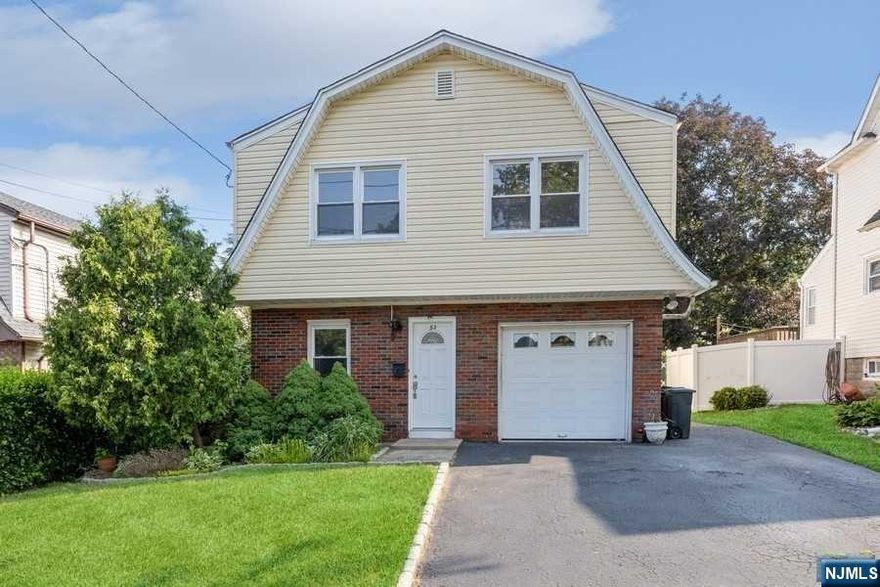 This freshly painted, sunny, and ideally located 3 BDRM, 2 FULL BATH home awaits its new owners who are ready to entertain, cook and enjoy a vine-covered patio in an enclosed backyard! Pull into your attached 1 car garage and enter into your oversized tiled Entry Foyer leading upstairs to the ranch-style layout, with hardwood floors throughout, or enter through a private door that leads you into the ground floor family room, den/office, FB, and summer kitchen in the rear of the home. The laundry is located within the garage with easy access to flip plumbing back inside the home. Located just three blocks from Main St., Public Transportation, and Herrick Park, two blocks from the Jr/High School, and just a few minutes from major highways 95 N/S, NJ Turnpike, and Rt 80, this property is ideal for anyone!