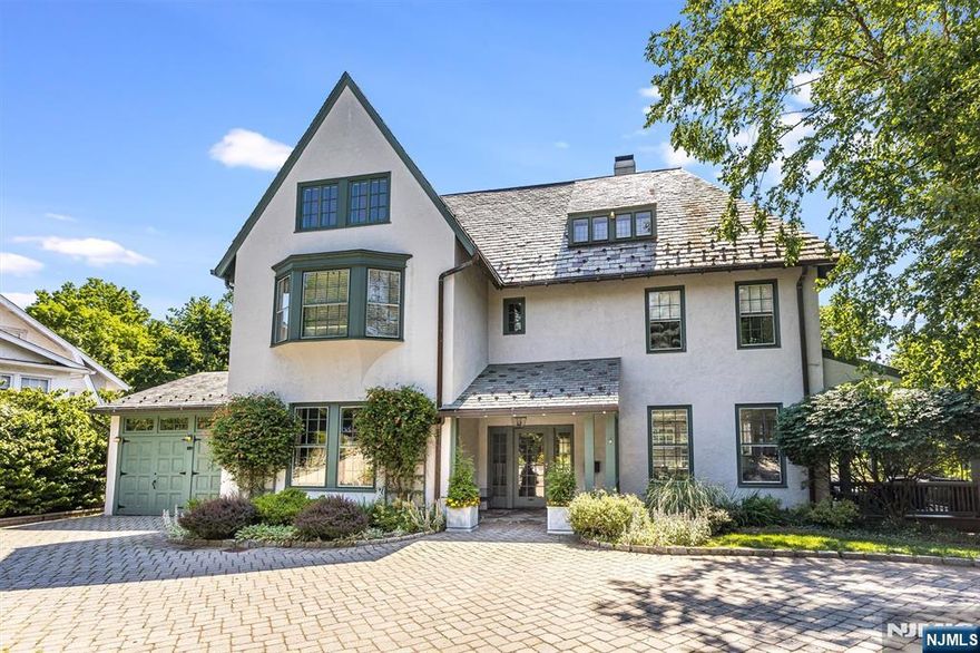 This distinguished Montclair home, built in 1877, blends historic charm with luxurious modern updates. Original architectural details, soaring ceilings and a grand layout across three levels are paired with a prime location just blocks to Watchung Plaza and Edgemont Park. Enjoy NYC skyline views and a resort-style backyard with terraced decks, a hot tub, koi pond, bluestone patio, gas fire pit, and professionally designed gardens. The designer kitchen is a showstopper, featuring Parsons cabinetry, SubZero fridge and Bluestar stove, marble countertops, a pantry, waterfall island, and Nanawall bifold doors that open to the deck, blending indoor and outdoor living. The 2nd floor includes a sunlit library landing with custom bookcases, 3 bedrooms including the serene primary suite with heated floors, dressing room with center island, and spa-like bath. Additional ensuite bedrooms, radiant-heated bathrooms, and a versatile 3rd floor with 3 bedrooms and office offer flexible living options. Extra amenities include Sonos speakers, soundproof gym/rec room, newer AC condensers and sprinkler system, whole-house generator, updated sewer line, electric pet fence and convenient attached garage. A rare opportunity to own a lovingly restored and impeccably upgraded home in the heart of Montclair.