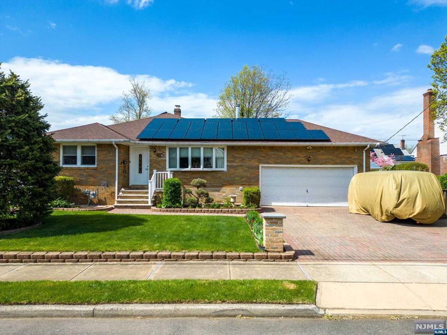 WELCOME HOME TO PERFECTION! SITUATED ON PROFESSIONALLY LANDSCAPED CORNER LOT, THIS HOME WILL NOT DISAPPOINT! Main Level Features Sun Filled Living Room with Built Ins and Wood Burning Fireplace, Well Appointed Kitchen with Skylight, Dining Room, Primary Suite w/ Full Bath, 2 More Generous Sized Bedrooms, Full Bath with Double Vanity, and Cedar Hall Closet with Laundry Chute. Walk Out Finished Basement is complete with Family/Recreation Room, Summer Kitchen with Dining Area, Den/Office, Full Bath, Laundry Room, Utility Room and Storage Room. Your Fully Fenced Private Backyard Sanctuary includes Outdoor Kitchen, Paver Patio, Storage Shed and Level Open Area for Play or Relaxation. Fully Owned Solar Panels are a Plus! Electric Car Ready Garage! Surrounded by Many Conveniences, Major Highway Routes and Blocks Away from NYC Bus Stop! THIS HOME HAS SO MUCH TO OFFER WITH ALL THE BELLS AND WHISTLES! IT WILL NOT LAST...DO NOT MISS OUT!