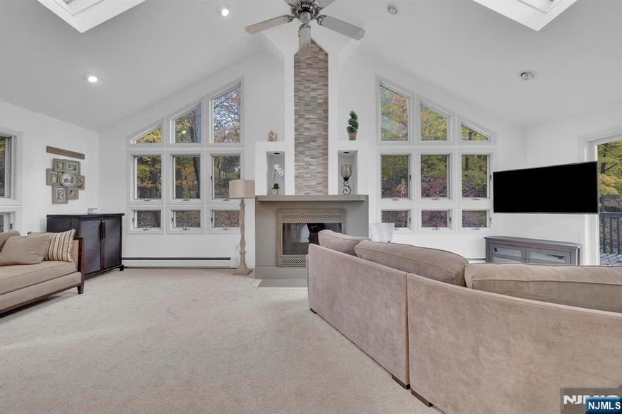 Welcome to 16 Dogwood Trail - a spacious 5-bedroom, 3-bath home blending comfort, natural light, and modern updates in a tranquil Randolph setting. The heart of the home is the enormous Great Room, featuring a focal fireplace, skylights and floor-to-ceiling windows offering sweeping views of the private, wooded backyard. A pair of sliders open to an expansive deck, perfect for entertaining or simply relaxing among nature. The chef's kitchen on the main, boasts abundant cabinetry, a breakfast bar, and flows seamlessly into a formal dining room ideal for gatherings.Also on the main level, the home offers three generously sized bedrooms and two full baths, while the ground level provides an amazing entertainment room, two additional bedrooms, a full bath, and a convenient laundry room along with access to the two-car garage. Freshly painted Great Room, new roof, multi-zone hot water baseboard heat, and central air ensure year-round comfort. Set on a quiet street within walking distance to Hedden County Park, and just minutes from the Randolph YMCA, train station, and top-rated Randolph School System. Enjoy privacy, convenience, and an ideal location - all wrapped in a home designed for everyday living and memorable moments.