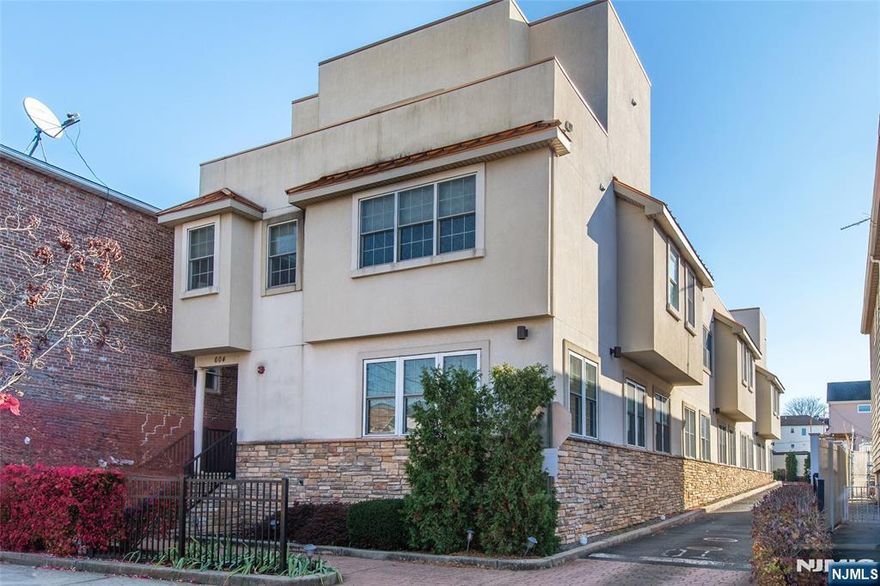 Welcome to one of Bayonneâ€™s most impeccably maintained condominiums, proudly offered by its original owner who has cared for every detail with exceptional pride. This stunning multi-level home is filled with abundant natural light throughout, creating a warm and inviting atmosphere from the moment you enter. The ground level features a sun-filled open layout with a spacious living room, dining area, and modern kitchenâ€”perfect for both everyday living and entertaining. The kitchen is equipped with granite countertops, a breakfast bar, and high-end stainless steel appliances, offering both style and function. A full bathroom and oversized pantry add convenience and valuable storage to this level. On the second floor, retreat to the expansive primary suite complete with a massive walk-in closet and a spa-like ensuite bath featuring a double vanity, a luxurious soaking tub for two, and a separate enclosed shower. A second generously sized bedroom with its own full bathroom sits just across the hall, providing comfort and privacy for guests or family members. The top level is truly specialâ€”an airy, light-filled loft that serves as the ultimate entertaining space, home office, or lounge. Step outside to a large private balcony with unobstructed southern Bayonne views, perfect for relaxing evenings or hosting gatherings. This floor also includes a convenient half bath and laundry room. Rounding out this exceptional home are two off-street parking spaces, a rare and highly desi