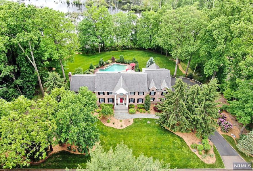 Classic & stately brick front colonial nestled on gorgeous acre property with saltwater pool & breathtaking outdoor oasis. Stunning private rear yard with views of mountains, nature area & reservoir! Beautiful updates throughout! Foyer leads to dining room with detail moldings. A wall of French doors open into the private library/living room. The elegantly renovated kitchen by Ulrich features large center island with granite/bar seating, glass cabinetry, top of the line appliances & door to multi level deck overlooking the pool. Kitchen flows to family room with year round views from the wall of windows & glass door to deck. Great Room features tremendous space with vaulted ceiling & gas fireplace. 2nd floor primary suite features soaring ceiling, large Palladian window, 2 walk in closets, & spectacular spa bath. 3 bedrooms, 2 baths & laundry complete the 2nd floor. Lower level is fully finished with outside entrance, media & entertainment area, wetbar, bath, & bonus guest suite!