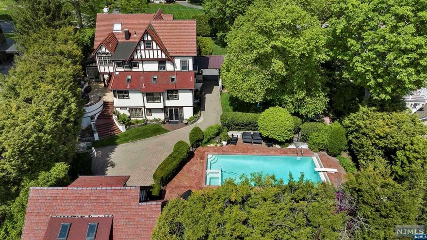 Visit www.NewJerseyProper.com The VIRTUAL TOUR link features a comprehensive video tour of this estate with additional photos, floor plans, and a complete interactive 3D model. Location! One of Ridgewood's premier homes in the most desirable part of town. Conveniently located just 300 yards from downtown, the coveted train station and the NYC express bus is a .7 acre paradise. This meticulously maintained & lovingly upgraded estate has so much character, charm & attention to detail. Features include 4 finished floors, radiant heated bathrooms, 2 terraces, 2 Juliette balconies, private well (for pool & sprinklers), automatic generator, custom mahogany woodwork, vintage (restored) fixtures, 7 skylights, 2 steam rooms, a sauna, Bradbury wallpaper, venetian plaster, extensive custom plaster work, upgraded plumbing, upgraded electric, lower level offers 5th bedroom option, an inground saltwater pool w smart controls, privacy landscaping & 2 car detached garage with finished loft