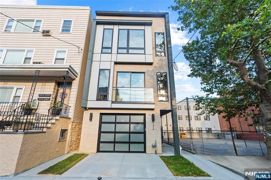 Discover sophisticated urban living in this stunning duplex at 32 Hancock in The Heights. This meticulously designed 3-bedroom, 2.5-bathroom residence offers an unparalleled blend of modern luxury and comfort. Step into a chef's dream kitchen, featuring top-of-the-line Samsung appliances, a breathtaking waterfall center island, and exquisite two-tone cabinetry adorned with elegant gold hardware. Throughout the home, you'll find a consistent theme of refined gold accents that complement the gleaming hardwood floors. The entertaining level also boasts a convenient powder bathroom with crisp white hardware and accents. The space is flooded with natural light from stylish black-framed windows, creating a bright and inviting ambiance. Enjoy seamless entertainment with built-in ceiling speakers, and experience ultimate comfort with a dual-zone HVAC system. Practical amenities abound, including an over-range pot filler for culinary convenience. The primary bedroom is a true retreat, offering a spacious walk-in closet and a luxurious ensuite bathroom. All bathrooms throughout the home feature modern lit and anti-fog mirrors, adding both style and functionality. Security and peace of mind are paramount, thanks to a Honeywell Home alarm system and a Ring video doorbell. Venture upstairs to your private rooftop oasis, where you'll be captivated by panoramic New York City views, perfect for entertaining or quiet reflection.