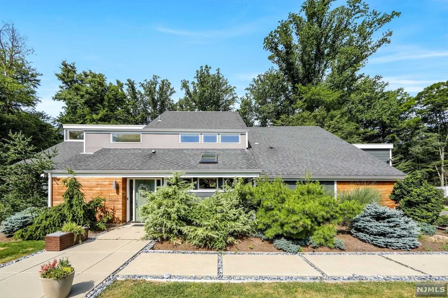 Welcome to this one of a kind hardy plank exterior mid century modern home nestled in the sought after Greenwoods section of Old Tappan- overlooking Lake Tappan. Featured in HGTV magazine for its unique Frank Lloyd Wright inspiration. Natural lighting from oversized windows & doors give off the ambiance of tranquility as you walk through this serene open floor concept. Details with elements of craftsmanship such as brick herringbone flooring in the entry foyer & floating solid mahogany staircase make the home unique. Not to mention, the luster of the walnut flooring, cathedral ceiling, & the custom library bookshelf with a sliding ladder as a final touch to perfection. The master suite boasts a vaulted ceiling, modern updated bathroom, & a cozy fireplace. The children's rooms are fun & whimsical with built-in staircases leading to lofts. Last, but not least, enjoy the private yard with a gunite saltwater heated pool, sundeck, & isolated fire pit to enjoy evenings under the stars.
