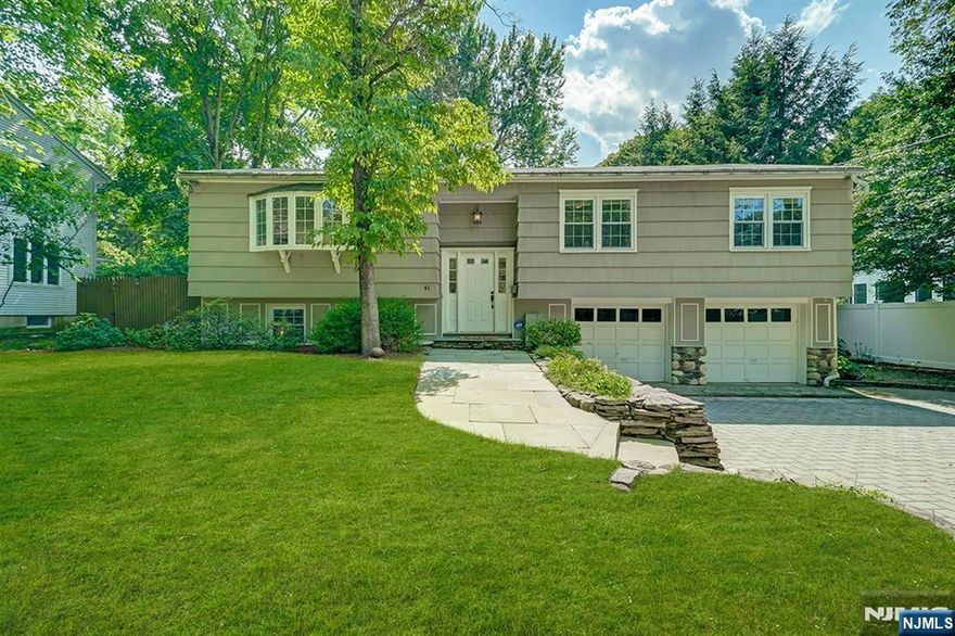 Welcome home to this bright, updated bi-level situated on a quiet, tree-lined street in Demarest. The main level offers an open and effortless flow between the living room, dining area, and kitchen, with French doors leading to a spacious deck for seamless indoor/outdoor living. The eat-in kitchen features high-end stainless steel appliances, granite countertops, and a custom granite table. Three sunny bedrooms are located on this level, including the primary suite with a walk-in closet and an updated en-suite bath complete with a separate makeup vanity. The lower level includes a large office/bonus room that can serve as an additional bedroom, as well as a family room with sliding glass doors that open to a covered stone patio. A mudroom and laundry room on this level provide added convenience, especially after spending time in the private, fully fenced backyard with its serene water feature. Freshly painted with natural wood floors throughout, this home is move-in ready and sure to impress.