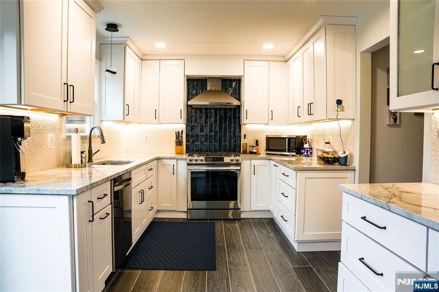 END UNIT at The Townhouses at Pequannock, Each unit has it's own driveway and oversized garage, 1400 sq feet of home living in the sought out town of peqannock!! All recently renovated, Kitchen remodel in 2022 with quartz count ertops, along w. new SS appliances (landlord leaving for buyer) w. heated flooring and walk out sliders to deck, 1ST fl has 8' ceilings, HW floor,DR, LR, 1/2 bath,baseboard heat 2 zones, A/C Central, 2ND floor has 9' ceilings, 2 bdrms w. full bathroom custom remodel stand up shower custom shower hardware, California closets throughout