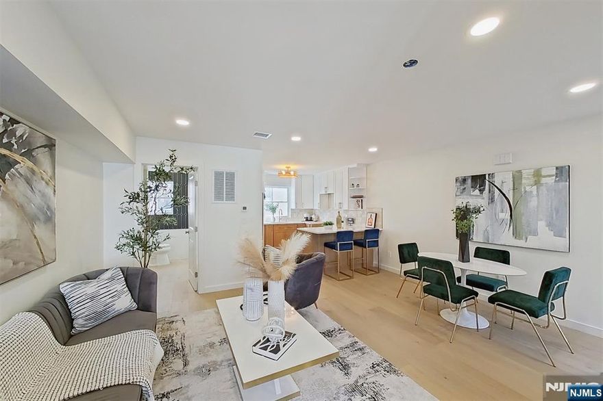 Javier Hill presents a rare opportunity to own a newly constructed townhome community in Passaic, NJ. This exclusive collection of eight thoughtfully designed two-story residences offers the space, privacy, and functionality of single-family living with the ease of modern new construction. Each home features a private, LED-lit entrance and direct interior access from a two-car garage with dedicated mechanical, storage, and laundry spaces. The main living level showcases a bright, open-concept layout ideal for entertaining and everyday living, highlighted by abundant natural light and a decorative pine wood partition that adds warmth while framing the staircase. The kitchen is both stylish and functional, featuring ceiling-height wood cabinetry with crown moulding, white granite countertops, open shelving above the island, full-size stainless steel appliances with range hood and pantry storage. A well-appointed half bath with timeless finishes completes this level. Upstairs, three generously sized bedrooms offer ample closet space, including a primary bedroom with a full walk-in closet. The full bathroom features modern fixtures, a deep soaking tub, glass shower doors, and a custom granite-topped vanity. Additional highlights include central heating and air conditioning, energy-efficient windows and doors and high-set windows for added privacy and natural light. Javier Hill delivers modern design, thoughtful details, and comfortable livingâ€”crafted for todayâ€™s lifestyle.