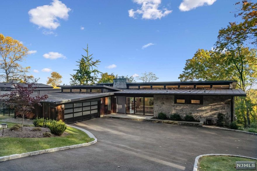 A Modern Mid-Century dream home w/expansive, breathtaking year-round skyline views enhanced by floor-to-ceiling walls of glass, 11' ceilings, & balconies on two-levels. Built in 1961 by a renowned engineer who worked closely with Louis Kahn. The home was completely renovated in 2016-17 & has an intensely original, minimalist interior, a study in proportion, light and scale. A refined palette of warm wood cabinets throughout is set off by white countertops in the kitchen & bathrooms. Abundant windows mean light streams through the open interior and sliding glass doors lead to balcony from upper-level living room & to patio from lower-level family room. Chef's kitchen, dining room, luxurious primary bedroom suite, 2 more bedrooms, 2nd full bath & powder room are also on upper level. Lower level has 4th bedroom, office/5th bedroom, huge family room open to patio, home gym & another full bath. The half-acre, deep property is lushly landscaped with raised beds & fully fenced backyard.