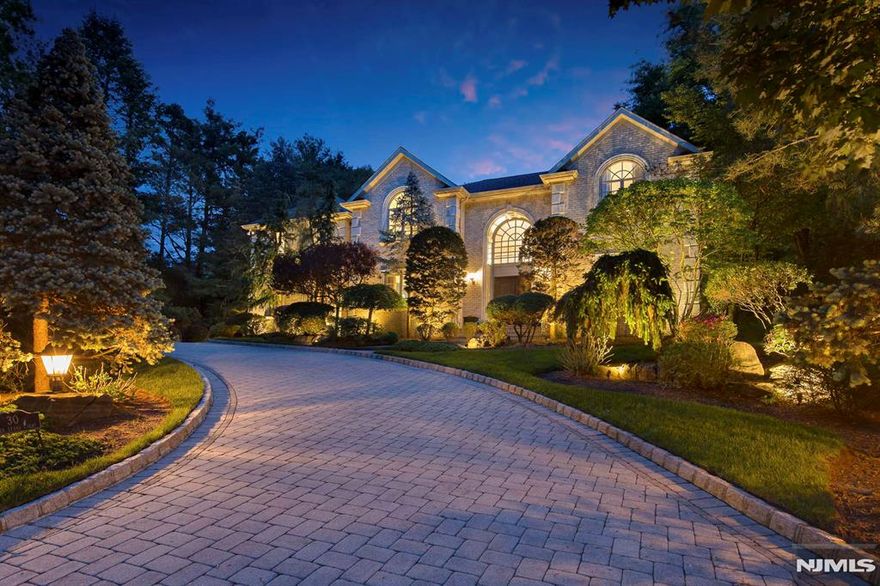 Nestled at the end of cul de sac, and among the most coveted Tenafly East Hill locations, this elegant APRX 7,500 SF (3 floors) brick home offers a blend of luxury, comfort, & sophisticated design. Custom built by renowned builder, Joseph Di Staulo, the grand entry foyer welcomes you w/soaring ceilings & an open floor plan, seamlessly connecting the formal living room, elegant dining room, & inviting family room, perfect for formal & intimate gatherings. The gourmet kitchen is complete with top-of-the-line appliances, custom finishes, and spacious breakfast area that opens to the secluded & private backyard. A large first-floor bedroom with a full bath and WIC is ideal for guests. Upstairs, the lux 2 room prime suite is a sanctuary, with a spa-like bath, generous closet space, & a balcony. 2 additional spacious BRs share a bath and nearby 2nd balcony overlooking the back waterfall, and a 4th BR is a Jr suite. All the upstairs bedrooms have high tray ceilings, their own spacious WICs and large windows. Finished walkout lower level featuring a BR, Bath, and Lrg Rec RM, media RM, wet-bar, & gym. The luxuriously landscaped backyard is a delight, with a waterfall, pond, & gazebo. Exclusive NJ location bordering multi million dollar estates, award winning Tenafly schools--Make it yours!