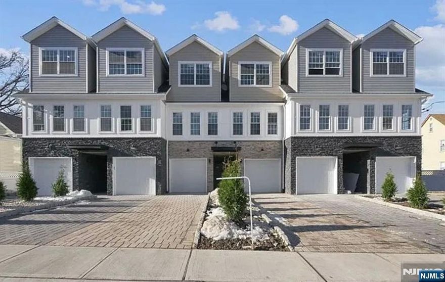 Discover modern living in this stunning end-unit townhome built in 2020. The ground floor offers a garage entrance, stackable laundry, a full bathroom, and a bedroom that opens to an outdoor patio. The second floor features a bright living room, an open-concept kitchen and dining area with sleek finishes, and a powder room. A private deck extends from this space, ideal for relaxing or entertaining. The third floor includes a spacious main bedroom with custom closet, a full bathroom, and another bedroom with its own custom closet. Located near Garfield train stations and NYC-bound buses, this home is perfect for commuters. Nearby parks, shopping, and dining complete the package, offering the perfect blend of style, comfort, and convenience. Don't miss this incredible opportunity!