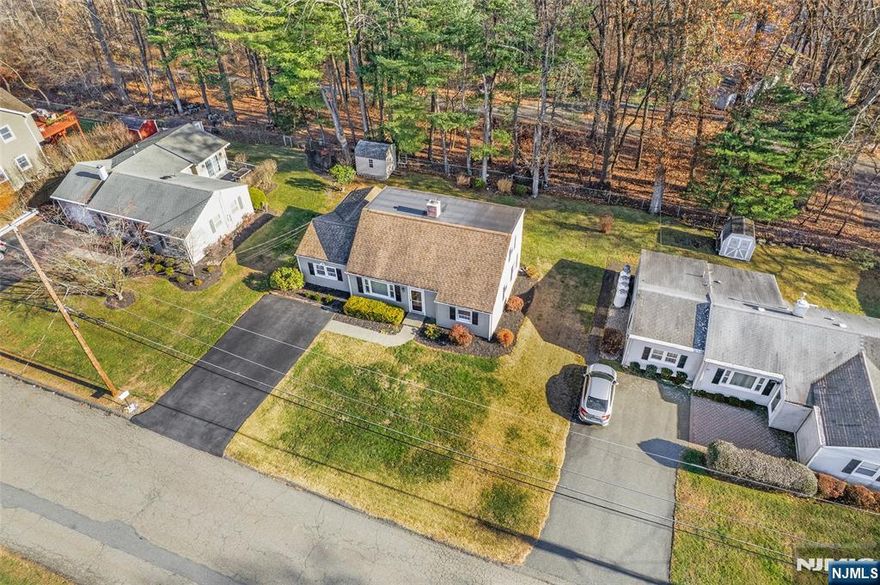 Welcome to 45 Memory Lane, a charming west front facing 3-bedroom, 2-bath plus bonus office home is set on a flat, private lot in Denville's highly desirable Beacon Hill neighborhood. The backyard offers peaceful wooded views & in the near distance a picturesque pond, creating the perfect winter backdrop for ice skating & year-round enjoyment of nature. Inside, the home features a flexible & functional layout ideal for both everyday living & entertaining. The first level includes a bright living room, an updated kitchen with stainless steel appliances, a comfortable family room, 1 bedroom, plus office/bdrm & a full bath. Upstairs, you'll find 2 additional bdrms & another full bath, offering space & privacy for fam, guests, or a home office. Major system updates provide peace of mind, including a furnace & water heater that are just 2 years old. Natural gas is available on the street for easy conversion in the future. Newer above ground oil tank is out back. A storage shed adds extra functionality, & the level yard is perfect for outdoor entertaining, play, or gardening. Conveniently located near the Mount Tabor Train Station with NYC-bound service, major highways, & just minutes to DWTN Denville, the historic Mt. Tabor Camp Association, Morris Plains, & Morristown Green, this home offers the perfect blend of serenity & accessibility. A rare opportunity to own in one of Denville's most desirable neighborhoods. This house is ready to welcome you home.