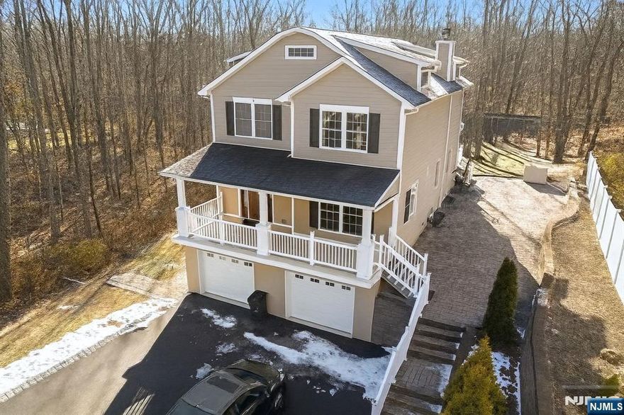 Custom built home with open floor plan. Gourmet kitchen complete with granite counters, stainless appliances, and large center island with breakfast bar seating. Family room with wood burning fireplace, wet bar, sliders to expansive rear deck. Living room with french doors to front entry and living room. Hardwood floors and recessed lighting throughout the first level. Second level features primary suite with a huge walk-in closet and spacious bath with granite, dual sink vanity, separate vanity/desk, jetted tub walk-in full tile shower, private commode, linen closet. Two additional large bedrooms with oversized closets and main bath on this level. First floor laundry room. Full walkout daylight basement with 4 bedrooms, Kitchen, laundry, bathroom. Charming front porch, spacious rear deck, and beautiful private paver patio. Walk to NYC train and downtown shops and restaurants. Award winning A+ rated Watchung Hills Regional High School. Full-day kindergarten. Short drive to Great Swamp Wildlife and Recreation area.