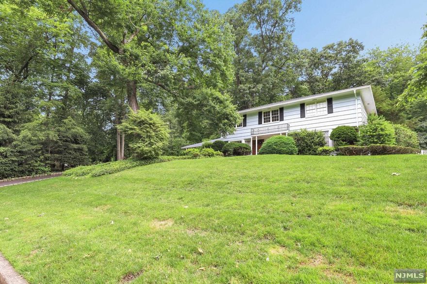 Location! Location! Location! This majestic home with lots of potential sits in an amazing neighborhood on a quiet cul-de-sac, on a third of an acre property with forest behind, makes this lovely 5-bedroom home a quiet retreat minutes from NYC transportation! Traditional layout with Large Living & Dining Room with bay windows and hardwood floors. Opens into eat-in kitchen with wall ovens and 5-burner cooktop, quartz counters, pantry & casual breakfast area. Family Room has cozy brick fireplace and large bay window bringing in tons of light. Mudroom/Laundry has convenient access to backyard and paver patio. Upstairs are 5 bedrooms incl. Primary Suite with Full Bath with standing shower. Basement is unfinished but has high ceilings, ideal for future build-out! Belgian-block lined driveway leads to 2-car side entry garage and access to very deep, fenced PRIVATE backyard. Roof replaced 2016. Fantastic central location and highly-rated school district! Won't Last!