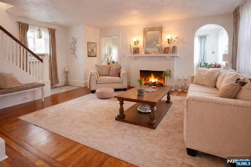 This elegant stucco and beam Tudor Colonial offers a rare blend of privacy and prime West Englewood location. While the front of the home faces West Englewood, the rear of the property enjoys access by way of a private shared drive off Taft Road, creating a uniquely peaceful and secluded setting. The home is nestled on a beautiful property surrounded by mature trees and refined landscaping, creating a serene, retreat-like setting. Inside, abundant natural light highlights inlaid hardwood floors and thoughtfully updated living spaces. The renovated kitchen features a double sink, newer appliances, and opens to a charming screened-in porch overlooking the tranquil grounds. Spanning four finished levels, each with its own bathroom, the home offers exceptional flexibility and comfort. The finished lower level has a large rec room with full bathroom provides an ideal guest. A rare detached garage, generous storage, and close proximity to transportation, houses of worship, parks, and schools complete this exceptional home.