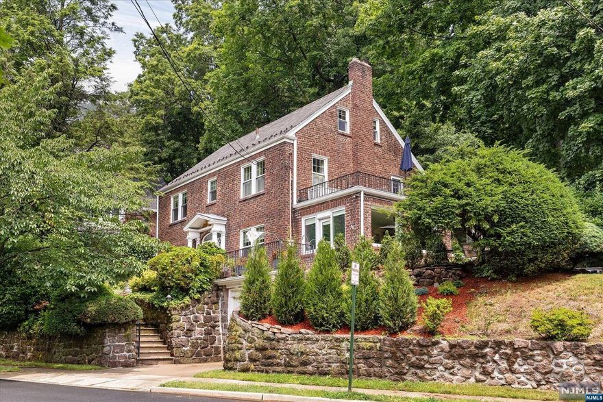 MAJESTIC BRICK & SLATE Colonial High Atop Leonia's East Hill with Spectacular Sunset Views! This spacious 5 BR home is located on Paulin Blvd- a prestigious residential street. Its center hallway opens to either the living room, formal dining room, or kitchen. The updated eat-in kitchen features granite, SS, & built-in refrigerator. While relaxing in the sunroom the wrap-around windows allow you to enjoy the outside and from here you can access the side patio for lounging as well as outdoor dining. A cozy FPL is shared by both the sunroom and living room. A huge primary BR features access to a terrace, a wall of closets and an updated primary BTH with tub and high-end combo bidet/commode. The 3rd floor boasts of 2 additional large BRS and a newer fully tiled bath with shower. The professionally landscaped grounds are truly picturesque. Features include hardwood flooring, 2 zone C/A/C, and all updated windows. Conveniently located near schools, NYC transportation, & all major HWYS.