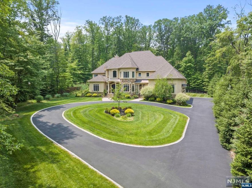 Welcome to this exceptional custom colonial home in one of Warren's most desirable locations. This beautifully maintained home offers luxury living with fine finishes and exquisite details. As you step inside, you'll be greeted by a grand entry foyer adorned with medallions on the floor and ceiling, complemented by a sweeping staircase. The centerpiece of the home is the two-story great room, featuring a coffered ceiling, a custom paneled gas fireplace, and floor-to-ceiling windows that overlook the private backyard and woods. French doors provide access to the deck, perfect for outdoor entertaining. The gourmet kitchen is a chef's dream, boasting two center islands, top-of-the-line stainless steel appliances, a copper farm sink, and granite countertops. A glass pocket door leads to a butler's kitchen with additional appliances and storage. Don't miss the opportunity to make this remarkable custom colonial home your own.