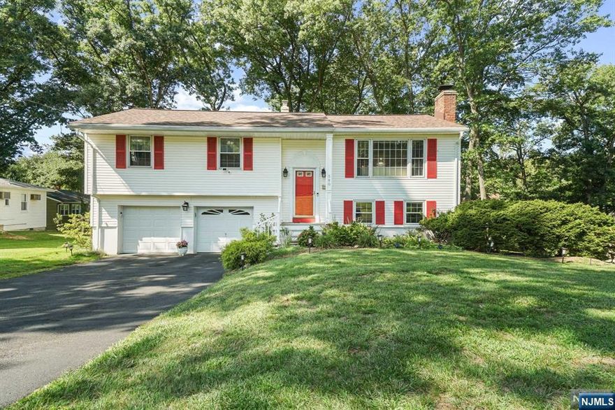 Welcome to this traditional bi-level home, located on a quiet, wide street in the Township of Washington. The impressive entrance leads to a sun-lit living and dining area, with oversized windows and beautiful hardwood floors. The kitchen, featuring a charming island and breakfast bar, offers a bright and inviting space that opens up to a delightful and relaxing deck shaded by trees. The main level includes the primary bedroom with a half bathroom, plus two additional bedrooms and a full bathroom. The lower level features a spacious family room with a dry bar and fireplace, a full bathroom, office area, a laundry area, as well as access to the backyard. Additionally, there is attached two-car garage. Ideal for both entertaining and peaceful living, this home is conveniently situated just minutes from major highways, shopping malls, restaurants, and places of worship.