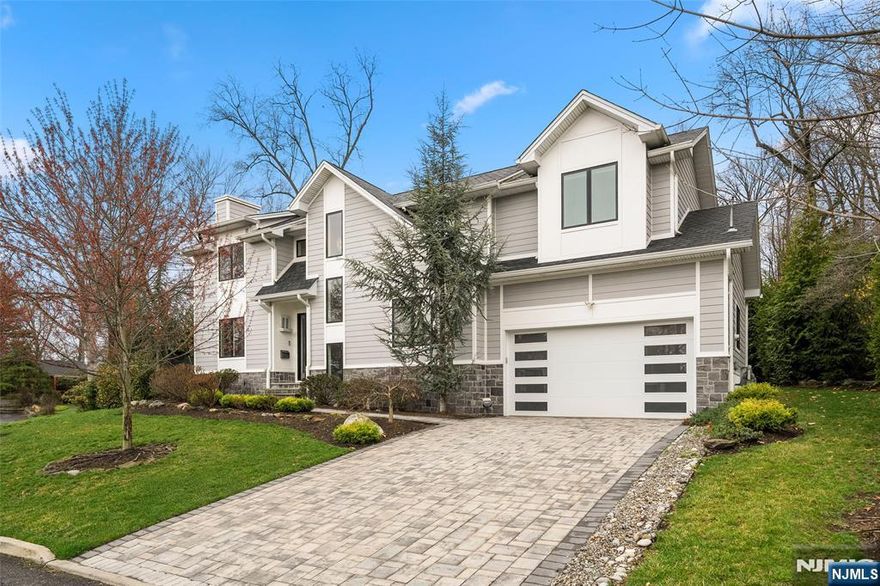 This stunning 5-bedroom Colonial, built by Lumaj Builders, is tucked away on a quiet street in highly sought-after Cresskill. The first floor features a gracious entry foyer, a sun-filled living room with a fireplace, a formal dining room, an eat-in kitchen, a powder room, and a mudroom leading to the attached 2-car garage. The second floor offers a spacious primary suite with a walk-in closet and a luxurious primary bath with radiant heated floors. This level also includes an en-suite bedroom, two additional bedrooms, and a Jack-and-Jill bathroom. Radiant heated floors in the bathrooms add an extra touch of comfort and luxury. The beautifully finished lower level is designed for both everyday living and entertaining, complete with a bedroom, full bathroom, wet bar, and recreation area. Additional highlights include a whole-house sound system, full-house generator, Nest doorbell, central vacuum, Tesla electric vehicle charger, and a brand-new dishwasher. The home has also been thoughtfully renovated with quality upgrades throughout. Outside, enjoy a beautifully private backyard with a patio, perfect for relaxing or entertaining. Located in a wonderful town with excellent schools and easy access to NYC, this exceptional home offers the perfect blend of luxury, comfort, and convenience.