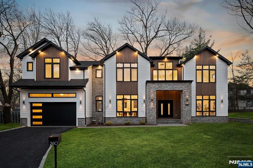Crafted by award-winning NJGCB, this stunning transitional new construction is ideally located on the east side of town, near houses of worship, schools, and major highways. Spanning approx. 6,000 sq. ft., it features 6 beds, 6.5 baths, and a seamless blend of modern luxury and functionality. The two-story foyer leads to an open layout with elegant living/dining areas, a glass-enclosed wine display, and a sunlit two-story family room. The gourmet kitchen boasts Thermador appliances and connects to the mudroom and two-car garage. A first-floor ensuite offers flexibility. Upstairs, the primary suite stuns with custom WIC and spa-like bath, plus 3 vaulted-ceiling bedrooms with ensuites. Enjoy a second-floor laundry and bonus lounge. The walk-out lower level includes a gym, media room, rec space with wet bar, bedroom, and bath. Sleek glass railings enhance the contemporary design. Modern luxury meets ultimate convenience!