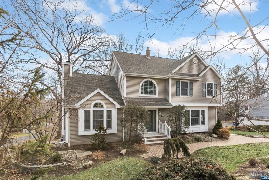 Come and see this spacious Colonial with charming curb appeal sitting on a deep lot! You'll love the two story Entry Foyer, Formal Dining Room with French doors to the large deck overlooking the back yard, Living Room and Great Room with skylights and stone fireplace. The Eat-in-kitchen is modern and spacious with a center island and separate Dining area. Upstairs you'll find the Master Bedroom with walk-in closet, laundry area and Master Bathroom with Jacuzzi tub. There are two additional bedrooms and a full bathroom upstairs as well. The finished walk-out basement has a Summer Kitchen, Living room area, Office/possible Bedroom, and Full Bathroom. 1 car built-in garage, whole house wired for generator, 2 zone central air. Close to shopping, commuter routes, NYC transit & William Paterson University!