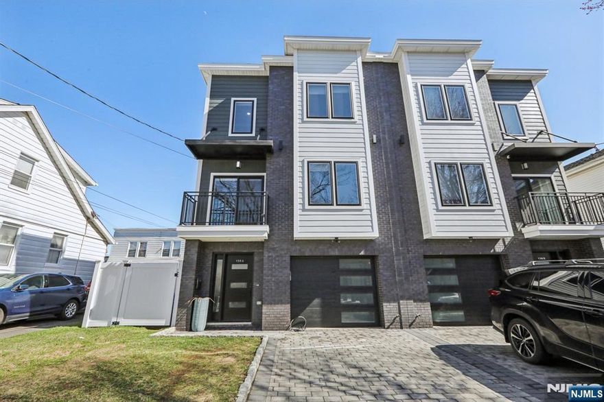 Beautifully maintained one-family duplex-style home featuring a 1-car garage and private driveway. This home offers 7 spacious rooms, including 4 bedrooms and 3.5 bathrooms, with thoughtful attention to detail throughout. The main level features a modern kitchen with quartz countertops, tiled backsplash, and stainless steel appliances, seamlessly flowing into the living and dining areas, with sliding doors leading to a private deck and balcony. The primary suite offers a private bath and generous closet space. The finished ground level includes a fourth bedroom, full bathroom, and a flexible office space with direct access to the backyard. Each unit enjoys its own private, fenced-in yard. Additional features include a 2-zone HVAC system with gas heat and central air. Conveniently located just 2"3 blocks from NYC bus service and PATH train access, making commuting simple and efficient. No HOA fees.