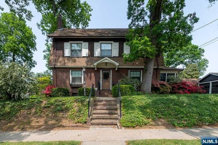 This stately two-family colonial in the desirable Spring Garden section of Nutley, New Jersey is a promising investment opportunity or a project for creating a spectacular single-family home. Owned by the same family since 1922, this property offers historical charm and vintage details, including solid wood doors and hardware. The well-maintained gardens with beautiful flowering bushes and shrubs add to the appeal. The home features two full apartments, providing the potential for rental income or the option to renovate it into a spacious single-family residence. With five bedrooms, two full bathrooms, and one-half bathroom, there is ample space for residents or tenants. While the property needs updating and some repairs, it is well worth the investment. The home's attractive features provide a solid starting point for renovation and modernization. There are also two fireplaces, adding a touch of coziness to the living spaces.