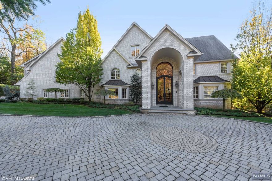 Welcome to this magnificent manor set atop a private, lush 1 acre with a resort-like backyard featuring a heated pool, jacuzzi, waterfall, outdoor kitchen, and entertaining area. The expansive and sunfilled entry foyer features a beautiful custom iron door and complimenting iron railing. It opens to a formal living room, sitting room, and family room, each fitted with a gas fireplace. The first level offers an extra-large chef's kitchen with Subzero and Viking appliances, a walk-in wine cellar, dining room, and french doors leading out the backyard. The second floor provides five generously appointed suites and an additional laundry room. The master suite features a sitting area, walk-in closets, and a spa-like bath. The additional suites enjoy walk-in and custom-designed closets. The lower level completes the home with sauna spa, recreation room and full bath. Award winning school system and 10 miles to NYC! Ready to move in.