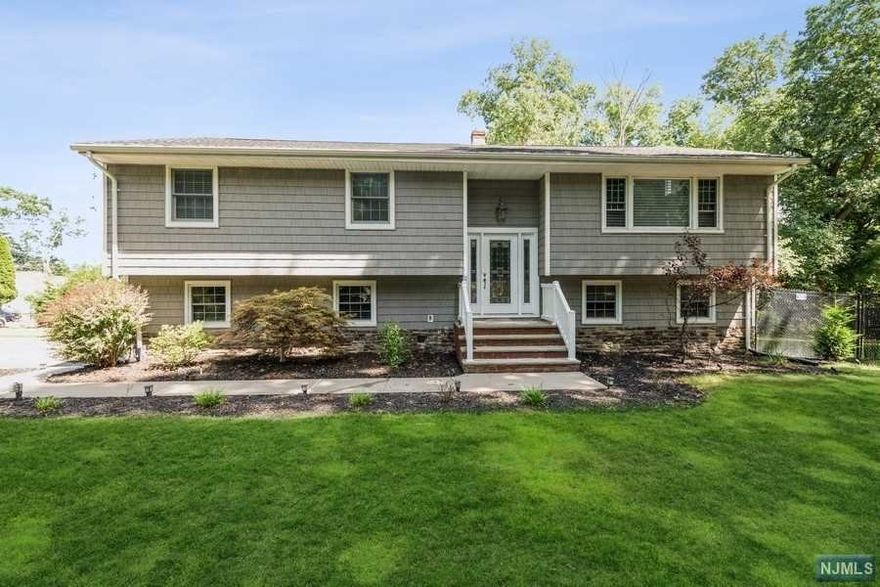 Newly updated home located on a corner property with entrance to the double driveway on the cul-de-sac. Ceramic tile floor in the entry foyer/coat closet, vaulted ceiling in living room with a gas fireplace, open floor concept to a formal dining room/ sliding glass doors to a maintenance free deck overlooking yard and hills to the east, an updated eat-in kitchen with a center island and stainless steel appliances. Hardwood flooring, hallway leading to 3 bedrooms, all with double closets. Updated full bath/shower over tub, main bedroom/walk in closet and a double closet/full updated bath. Lower level family room, new full bath, bedroom,(perfect for extended family) oversized 2 car garage/laundry and storage. Large private property, underground sprinkler system for shrubs. Maintenance free exterior/vinyl and stone veneer foundation. Excellent location near NYC train, busses, stores, schools and parks. Truly move-in ready.