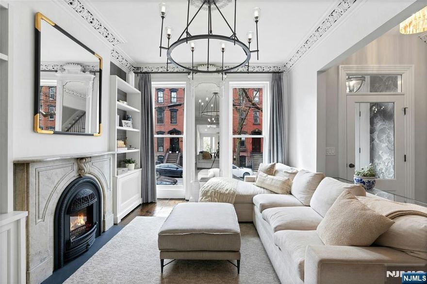 Welcome home to a masterful blend of historic grandeur and modern refinement. Originally constructed in the late 1800s, this exceptional 18x100 brownstone has been meticulously restored to preserve its timeless character while introducing sophisticated contemporary upgrades. Rich architectural details abound, including exquisite ceiling moldings, elegant marble fireplace mantels, a sweeping staircase, intricate ironwork. The parlor level is designed for both everyday living & elevated entertaining, featuring custom built-ins throughout the living room and a stunning chefâ€™s kitchen. Bathed in natural light, from a skylight with several windows this level flows to a spacious deck overlooking a landscaped garden & yard. Upstairs, the home offers generously proportioned BRs with custom closets throughout. The top-floor primary suite serves as a serene sanctuary, complete with a spa-inspired bath, heated floors, and a windowed walk-in closet. Additional BRs provide flexibility for family, guests, or a home office. Currently configured as a legal 2Fam, the home features a pristine 1BR garden Apt, ideal for supplemental income, the existing interior staircase provides the flexibility to utilize the residence as a 1Fam home. Just moments from the charm & vibrancy of Hamilton Park, with boutique cafes, acclaimed restaurants, top-rated schools. Easy access to Parking & PATH transportation. This exceptional residence offers a lifestyle of both tranquility and connectivity.