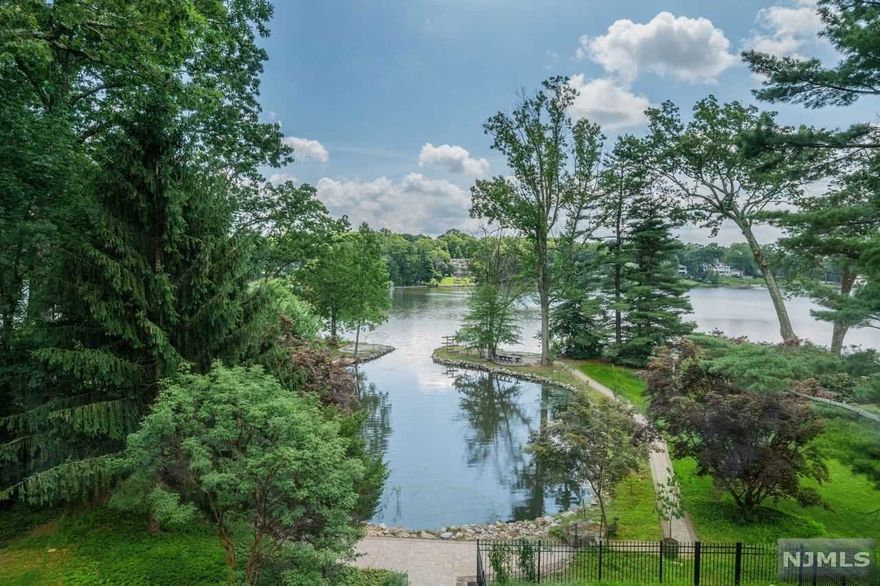 Sun filled lakefront with sweeping views of idyllic Mountain Lake, this freshly painted custom home has a striking open floor plan and unique architectural features, creating fabulous entertaining spaces throughout. The lake cove at your backyard provides an easy access for water activities. Enjoy swimming, fishing, sailing, kayaking, canoeing or ice skating from your back door! Both the first floor living room and lower floor family room have wall to wall windows highlighting the lake views, wood burning fireplaces, wet bars with a sink and beverage fridges. The gallery overlooking the living room is a perfect multi purpose space! The kitchen has custom oak cabinetry and access to the upper bluestone patio. It is adjacent to the dining room which boasts coffered ceilings and large windows. The first floor primary bedroom suite has plentiful closet space. This is a lifestyle!