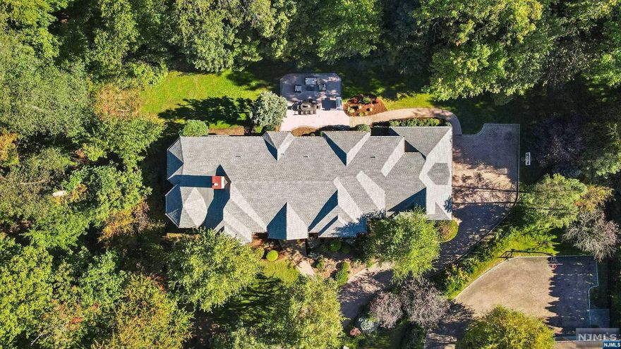 Rare chance to live at the end of a coveted cul-de-sac on Tenafly's East Hill. Expansive all brick Center Hall Col. w/ over 7,000 sqft across 3 fls, situated on over an acre surrounded by greenery & privacy. 1st fl offers a luxurious open floorplan w/high ceilings & spacious rooms. The grand 2-story EF flows into a lovely FDR. A bright EIK opens to a showstopper 2-story Grt Rm w/floor-to-ceiling windows. A modern dual-sided FPL connects the Grt Rm to the FLR, beside which is an elegant windowed office with serene views. Ensuite Bed/bth, Mdrm & Lndry round out the 1st Flr. The 2nd lvl does not disappoint w/expansive primary suite w/soaring ceiling & windowed sitting rm plus 2 WICs & spacious primary bth. 3 addl bright & gracious ensuite BRs complete the 2nd lvl. The LL is made for entertaining, ft rec space, game rm w/wet bar, theater, bonus rm & storage. The lush BKYD will impress you w/mature evergreens, an oversized paver patio & plenty of flat yard. Close to Top Schools & NYC