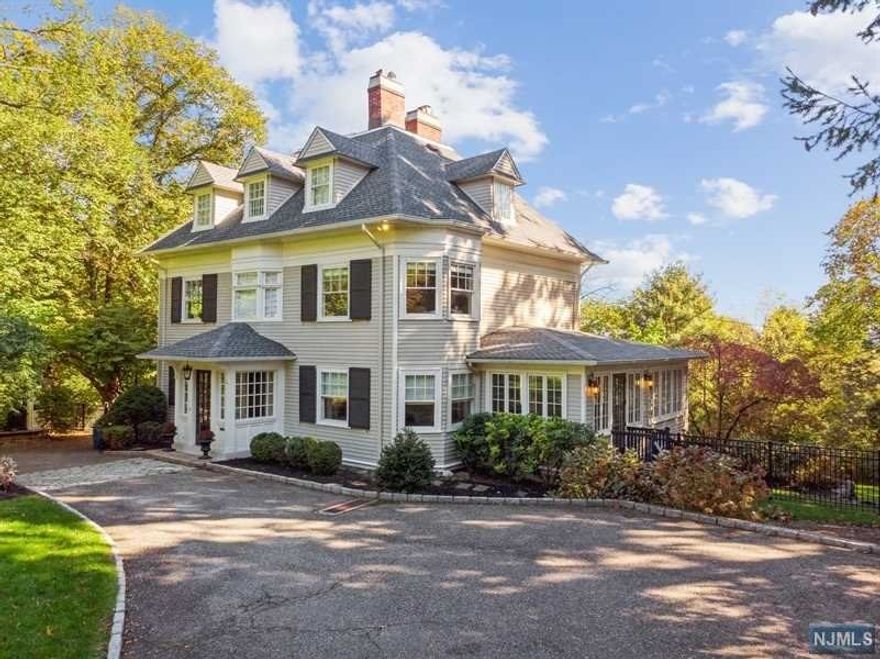 This turn century Georgian Colonial rests on nearly an acre of lush property with year round skyline views. The home is replete with beautiful period details and filled with modern amenities. Period details include crafted mill work, picture frame moldings, wainscoting, built-ins, and gleaming hardwood floors. Updates include fabulous new kitchen with crisp white cabinetry, high end appliances like Wolf cooktop and SubZero refrigerator, butlers pantry with wet bar, wine fridge and second dishwasher plus mud room. Expansive primary suite features fireplace, sitting area and luxious bath with soaking tub, oversized shower, dual vanities and heated floors. Beyond is an impressive custom dressing room. Lower level has new flooring, room for media, games and exercise plus walk out to blue stone patio with pergola. Enjoy view from expansive deck. 4-Car garage. Just unpack and enjoy