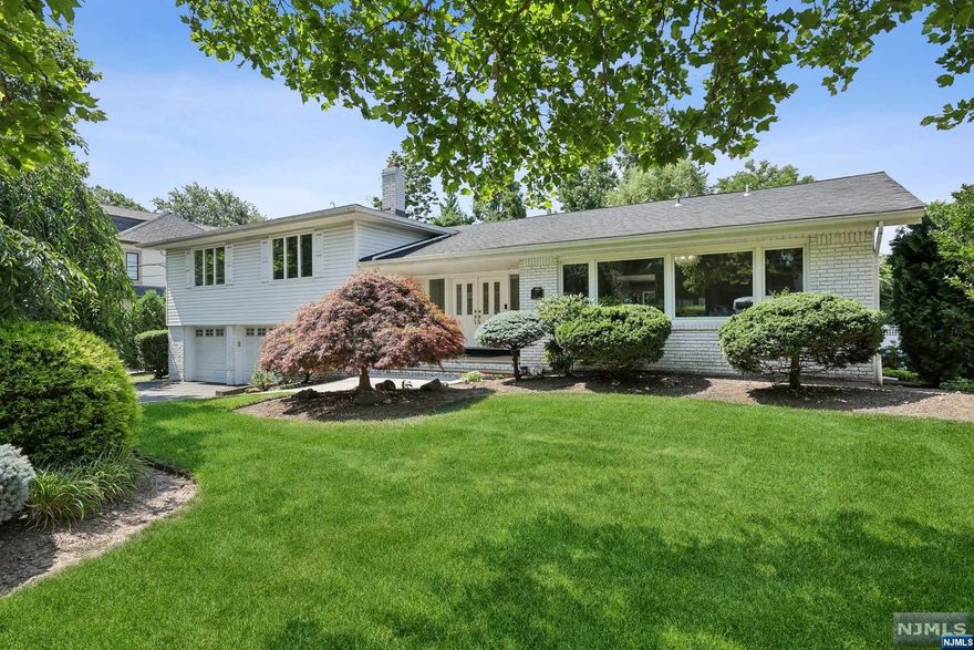 Introducing a beautifully renovated split-level residence in the prestigious North Cliffs section of Englewood Cliffs, showcasing a modern open layout. Step into the spectacular great room, which boasts soaring ceilings and a wall of windows, offering breathtaking views of the beautiful pool, patio, and yard. This space is seamlessly connected to a chef's kitchen equipped with custom cabinetry and high-end appliances. The upper level features three spacious bedrooms with two renovated bathrooms. The lower level includes a versatile room suitable as a bedroom or office, plus a half bath. Explore the spacious, fully finished basement with a rec room, ample storage, and laundry area, with an outside exit to the private, fenced backyard ideal for entertaining. Situated in a prime location, this home offers low taxes and is in close proximity to NYC and major highways, providing ease of access to a plethora of amenities and conveniences.