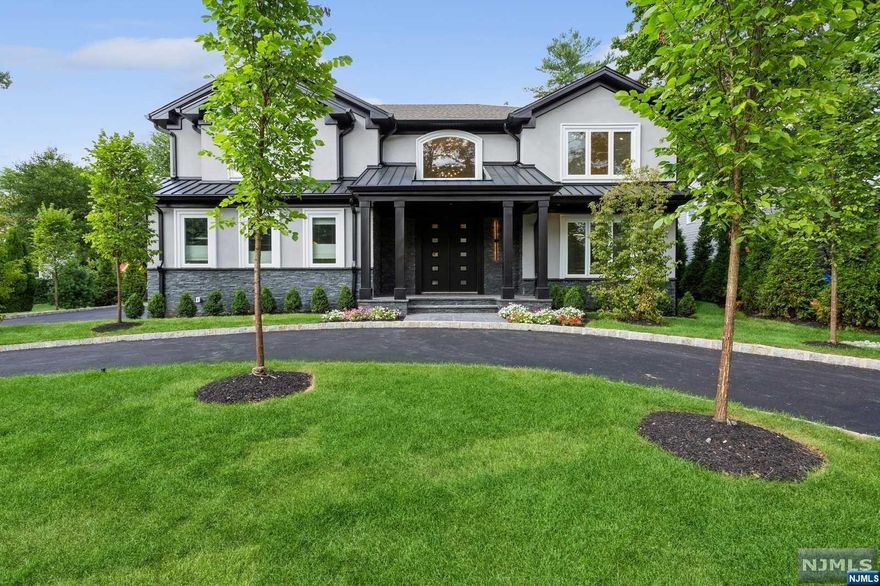 Experience luxury living in this nearly new home situated on a flat half-acre property in Tenafly. Featuring a double entry foyer with an open concept layout, this home offers a spacious dining room and a family room with a fireplace. The beautiful kitchen boasts a large waterfall island. The first floor includes a full bathroom, guest bedroom, pantry closet, and access to a very large two-car garage with 13-foot ceilings, perfect for installing. The kitchen opens up to enclosed patio with an outdoor kitchen. The second floor includes a bedroom with an en suite bathroom, two additional bedrooms connected by a Jack-and-Jill bathroom, and a primary suite with walk-in closets and a lavish primary bathroom. The fully finished walkout basement offers 9-foot ceilings, a full bathroom, and a bedroom/office. The home also features a circular driveway and stunning landscaping.