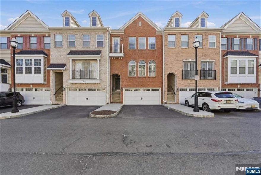 Welcome to this beautifully maintained brownstone-style townhome built in 2008 by Centex Builders, offering approx. 2,369 sq ft across three levels. This spacious home features 3 bedrooms, 2 full baths, and 2 half baths with hardwood floors throughout. The main level offers a bright living and dining area with floor to ceiling window and tray ceiling. In addition, there is a powder room, and an open family room with a gas fireplace leading to a gourmet kitchen with center island, granite countertops, 42â€ cabinets, stainless steel appliances, separate pantry and access to a private deck. Upstairs features a large primary suite with tray ceiling, walk-in closet with custom organizers, and en-suite bath with jetted tub, separate shower, and double vanity. Two additional bedrooms, full bath, and laundry room complete the level. Ground floor includes a versatile recreation room/office with a half bath and access to another private patio. Enjoy unobstructed meadow views, an oversized garage, and double driveway. Dual-zone HVAC with smart home with Nest thermostats and primary bedroom lighting. Low taxes & HOA. Convenient to NYC transportation & free shuttle to train station, schools, parks, shopping, and dining.