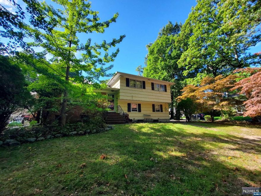 Spacious home, very large property located on the Westside in desirable Ridgewood! Near schools, shopping, parks, downtown, transportation...everything wonderful Ridgewood offers! Four levels of living space! First floor offers an open layout, updated kitchen, living room with fireplace, dining room, enclosed porch/ future den/family room. Features include hardwood floors, skylights, 2 car garage, central a/c, gas baseboard heat. Great layout for extended family living- ground floor family room or 4th bedroom or office with private outside entry. Make it your very own home sweet home! Includes a one year american home shield home warranty.