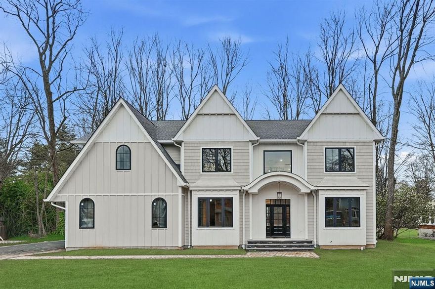 Welcome to this luxurious new-construction 6-BR, 6.5-bath Center Hall Colonial set on a level 0.38-acre lot in one of Florham Park's most sought-after neighborhoods. A custom luxury-grade statement front door introduces the exceptional craftsmanship throughout. The grand 2-story foyer is flanked by formal living and dining rooms.The sun-filled double-height family room with floor-to-ceiling windows is anchored by a gas fireplace and flows seamlessly into the chef's kitchen featuring premium panel-ready appliances, a large quartz center island, quartz backsplash, walk-in pantry, bar area, and breakfast area. Arch glass doors open to a paved patio and expansive backyard, ideal for indoor-outdoor living. The main level includes a private en-suite bedroom with walk-in closet, ideal for guests, a powder room with Carrara marble vanity, dedicated home office, mudroom, and direct access to the two-car garage. The second level offers 4 en-suite bedrooms, including a luxurious primary suite with dual walk-in closets and spa-inspired bath, plus a convenient laundry room. The fully finished lower level adds a recreation room, media lounge, bedroom, and full bath.Enhanced by custom millwork, designer lighting, refined architectural details, and exceptional curb appeal, this home is ideally located near shopping, dining, commuter routes, library, recreation facilities, and top-rated schools. Low taxes and a 10-Year Builder Warranty complete this offering.