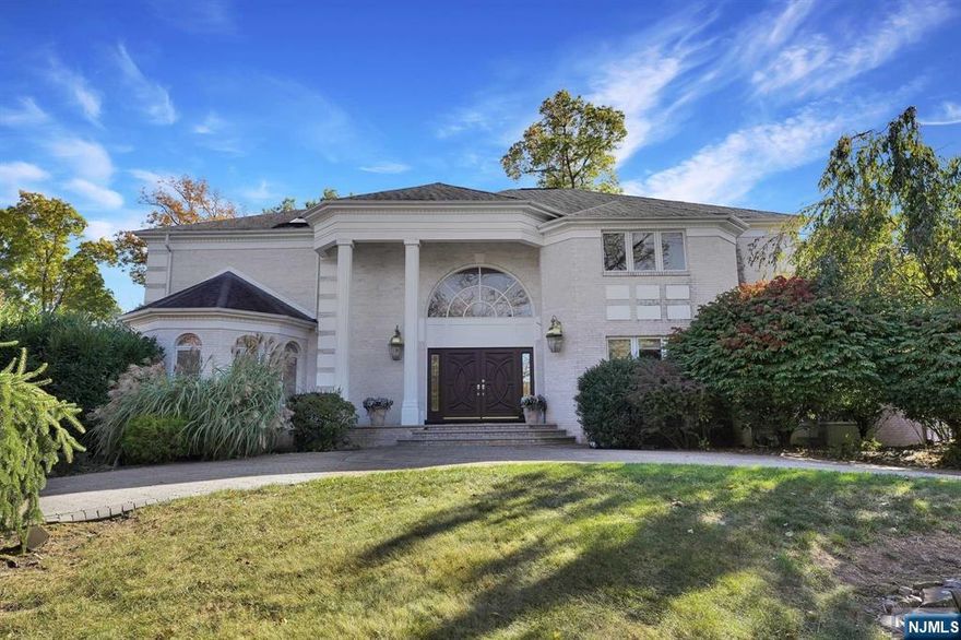5 BR 6.5-bath colonial home, situated in tree-lined neighborhood. Paver circular driveway leads you to a 3-car garage, this residence exudes curb appeal. Step inside to a 2-story foyer featuring double doors, winding staircase & marble flooring. Open floor plan connects the main living areas, including 1 of 2 primary suites. Suite boasts walk-in closets & spa-like bathroom & hallway that leads into an all-glass sunroom. 2-story great room w/ soaring ceilings, floor-to-ceiling windows & hardwood floors, all centered around a double fireplace that gracefully connects to the family room. Kitchen is a chef's dream, featuring center island, SS appliances, double oven & pantry. Access to the Trex deck overlooks the fenced-in flat backyard. Elevate your living experience w/ a 3-level elevator that takes you to the 2nd floor, where you'll find a 2nd primary suite complete w/ 2 balconies. 2 additional BR, each w/ en-suite bathrooms & walk-in closets. Ll walk-out adds more living space.