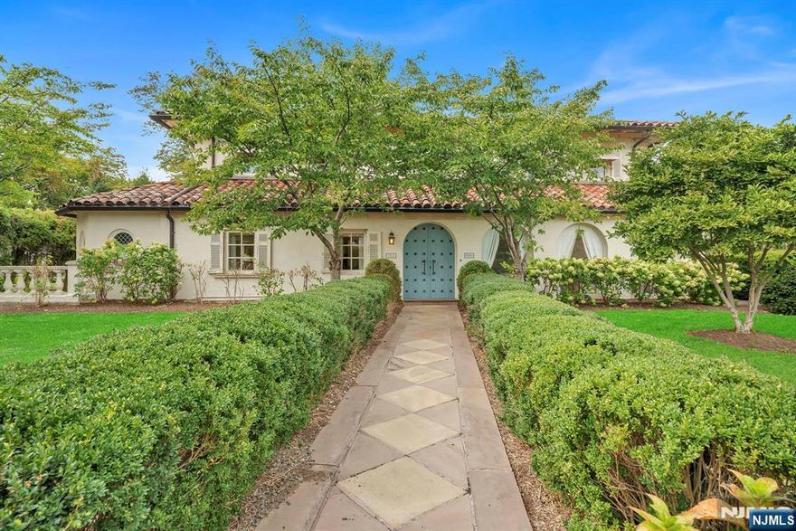 Built in 1927, this Spanish Colonial Revival estate offers 4,866 square feet of elegant living space on nearly half an acre in one of Glen Rockâ€™s most distinguished residential settings. Defined by its mission tile roof, arched entries, and original millwork, the home blends historic character with expansive interiors suited for modern living. High ceilings enhance every level, beginning with a grand living room with fireplace, a sunlit family room, and a front sitting area enclosed by a series of large arched windows. The formal dining room is crowned with architecturally detailed coffered ceilings, while a library with built-ins provides a refined retreat. A versatile kitchen with pantry and a well-placed powder room complete the main level. Multiple exits lead outdoors to a private side courtyard and to a patterned-paver driveway that extends to the detached three-car garage. The upper level offers five bedrooms and two full baths, with the primary bedroom serving as a serene focal point for the floor. The finished lower level expands the living space with a recreation hall, media lounge, custom wine cellar, full bath, laundry, and ample storage. Landscaped grounds and extensive hardscaping unify the exterior and reinforce the estateâ€™s architectural presence. This is a rare opportunity to own a residence of lasting quality and distinction in the heart of Glen Rock.