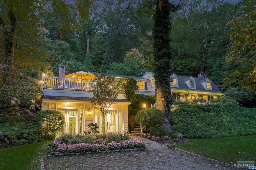 Glorious gardens in a truly private setting. This custom colonial home is elegantly appointed, professionally decorated and richly detailed. Bonus of a first floor bedroom ensuite with private patio. The primary on the 2nd floor has architectural windows for abundant light, luxurious bath with soaking tub and private elevated deck overlooking custom designed gardens. Enjoy privacy while taking in the nature views from every window. An updated kitchen with dining room opens into the family room with vaulted ceiling. Spill outside on the front veranda or relax in the privacy of the back patio adjacent to the lush gardens. Practice wellness in your private gym. Abundant parking on two driveways with attached 2 car garage. Saddle River NJ is a premier town noted for privacy, oversized lots, low taxes and minutes to every convenience, fine dining and abundance of shops, entertainment & parkland. Owner holds NJ RE license.