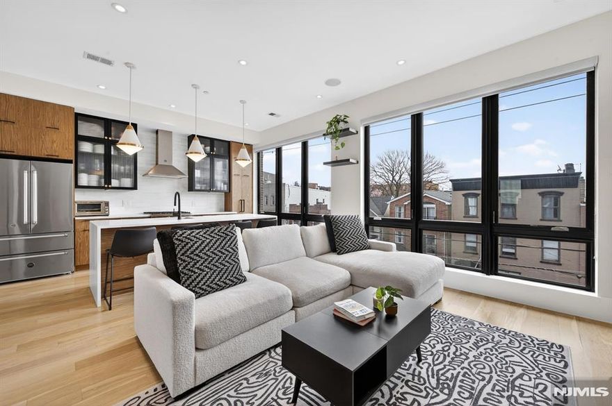 Perched in the heart of Jersey City Heights, 339 Palisade Ave #3 is a stunning 3-bed, 3-bath duplex blending modern design with everyday comfort. Soaring 10-ft ceilings and floor-to-ceiling windows fill the home with natural light, while the open-concept main level features in-wall speakers and custom roller shadesâ€”perfect for both entertaining and relaxing. The chefâ€™s kitchen shines with Bertazzoni stainless steel appliances, two-tone cabinetry with glass accents, and sleek white quartz countertops with a waterfall island. This level also includes a spacious bedroom, full bath, and a conveniently located LG washer/dryer. Upstairs, the private primary suite offers a custom walk-in closet and spa-like ensuite with dual vanity, glass shower, and heated, lit mirrors. A third bedroom with custom closets, another full bath, and a second private entrance add flexibility. Enjoy a private rooftop with breathtaking NYC skyline views, pre-wired for soundâ€”ideal for entertaining or unwinding. Additional basement storage included. Nearby parking available for a fee.