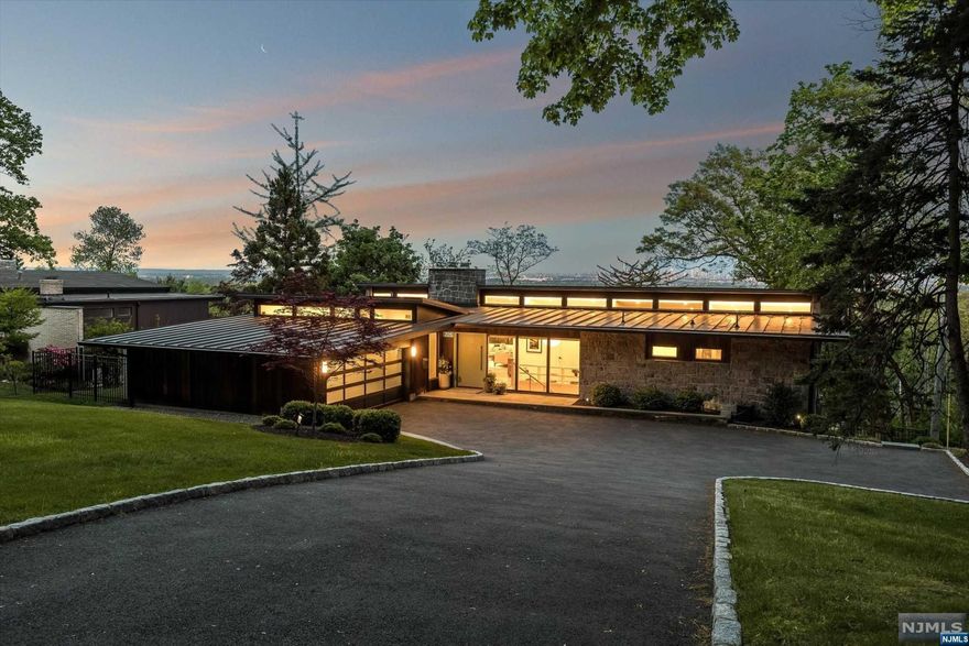 Absolute perfection is what you will find in this stunning Mid-Century Modern gem. Spectacular year-round NYC skyline views, flr to celing wndws, massive 11-ft. ceilings, 2-stry patios & orig Mid-Century dtls will take your breath away. Built in 1961 by prominent engineer August Komendant. Gut ren in 2016, preserving the orig architecture while integrating loads of modern conveniences! Kitch & bthrms reimagined in 2022 w/ meticulous attention to dtl. Gorgeous kitch w/ quartz cntrtop, ceramic tile backsplash & marble waterfall islnd flows into expansive & lght-filled lvng & dining rm w/ cstm banquette & statement stone FP. Prim ste w/ NYC views includes direct access to deck, WI closet & spa-like bth w/ cstm cabinetry, deep soaking tub & hted marble flr 2 more bdrms & 1.5 bths round out 1st flr. LL w/ 4th bdrm, ofce (w/access to patio), WO rm, full bth, flex space & generous closets. The sophisticated but cozy fam rm w/ cstm bar & sliders to patio. Set on over .5 acres.