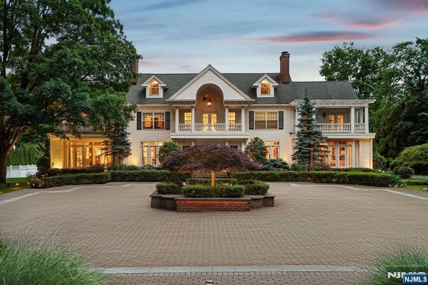 Tucked behind the gates of prestigious Llewellyn Park, this distinguished estate blends timeless elegance with modern luxury on nearly 2 acres. Rebuilt from the foundation in the 1990s and beautifully renovated in 2022, the 6-bedroom, 8.3-bath residence spans five levels with elevator access. A grand staircase and soaring ceilings lead to herringbone wood floors, arched doorways, and sun-drenched living spaces. The formal living room with a marble fireplace opens to a sun-drenched sitting room, while a character-rich office with a spiral staircase offers direct access to the primary suite above. The banquet-sized dining room, adorned with a Carrara marble fireplace and Murano-style chandelier, flows into the chef's kitchen featuring radiant heated floors, top-tier appliances, and a bright breakfast area. Upstairs, the expansive primary suite is a private haven with dual spa baths, two walk-in closets, a dressing room, gym, coffee bar, and a serene balcony. A separate level holds a recreation room with en-suite bath, sitting area, and storage. The finished basement includes a custom, soundproofed recording studio ideal for music, podcasting, or content creation. Outside, enjoy a heated infinity pool, spa, pergola with retractable awning and fireplace, sport court, and a separate 1-bed/1-bath Carriage House perfect for guests. Sq footage is apppx *