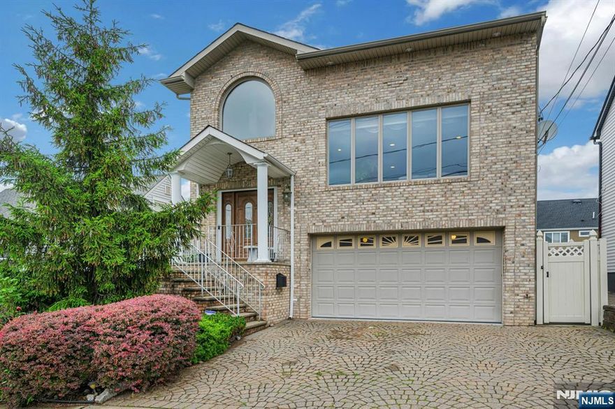 Welcome to this elegant 4-bedroom, 3.5-bath brick Colonial, offering a spacious "mother/daughter" ground level suite! Nestled in a quiet, desirable neighborhood, this home boasts vaulted ceilings, generous living spaces, and exquisite finishes throughout. Step into the grand foyer and into the expansive living room featuring soaring ceilings and a cozy gas fireplace perfect for relaxing or entertaining guests. The formal dining room sets the stage for memorable meals and celebrations, while the oversized eat-in kitchen offers ample cabinetry, updated appliances, and direct access to a large deck, ideal for outdoor dining and summer barbecues. Upstairs are three bedrooms with the luxurious primary suite being a true retreat, complete with its own private balcony, a full en suite bathroom with a soaking tub & separate stall shower. A standout feature of this home is the private in-law suite with its own entrance. This fully self-contained living space includes a living room, bedroom, kitchen, full bath and laundry. Outside, enjoy a beautifully landscaped, fenced-in yard with tumbled pavers, mature privacy trees, and maintenance-free vinyl fencing creating the perfect setting for both quiet relaxation and outdoor entertaining. 1.2 miles from the Lyndhurst NJ Transit Station with access to NYC.