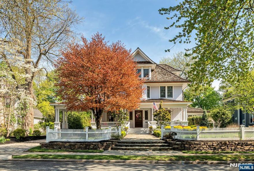 Set on a breathtaking 280-ft landscaped property along prestigious Spring Avenue, this exceptional 5-bedroom, 4.5-bath Colonial is surrounded by some of Ridgewoodâ€™s most iconic homes, offering a rare blend of timeless beauty and modern luxury. A graceful, curved white picket fence, port cochere, and cedar roof create outstanding curb appeal, while the covered front porch invites slow mornings and peaceful evenings. The backyard is a private retreat with a rear deck, greenhouse, sport court, vegetable garden, fenced lawn, and a 3-car garage with a finished loft/studio. Inside, rich original woodwork, a dramatic 3-story staircase, leaded glass French doors, stained glass windows, and coffered ceilings add warmth and character. The newly renovated custom kitchen features a 9-foot island, top-tier appliances, a cozy fireplace, and oversized sun-filled picture windows that bring the outdoors in. Formal living and dining rooms, a private office, and an updated family room with walls of windowsâ€”plus an adjoining mudroomâ€”offer both elegance and ease. Upstairs, the serene primary suite with spa-like bath is complemented by four additional bedrooms and a laundry room. The lower level adds a versatile family room, guest suite, new full bath, second laundry, hobby room, and ample storage. Ideally located near top-rated schools, downtown Ridgewood, and NYC transportation, this is a truly special home ready to be enjoyed for years to come.