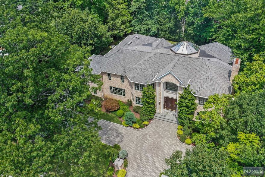 Manificent Brick Colonial set on almost a 1/2 acre on the north side of Englewood Cliffs. This unique home boasts a Central Atrium which is visible on both the first and second levels and brings natural light throughout the home. The Main Level includes: a huge Living Room with fireplace, Formal Dining Room, octogonal Great Room that exits to a balcony, a Gourmet Kitchen with Breakfast Area, Guest Powder Room and a Guest Suite that features a Living Room, Bedroom and Bath. The Guest Suite can also be used as 2 Home Offices. The Second Level includes: a Master Bedroom Suite and 4 Additional large Bedrooms with 2 Bathrooms. The Master Bedroom Suite boasts a Sitting Room with fireplace, a large Bedroom, 2 walk-in closets and a luxurious Bathroom with a steam shower and whirlpool tub. An additional Library/Office can be entered from both the Master Suite and the hallway. The Basement is fully tiled and has several windows and an outside exit. A Unique Offering!