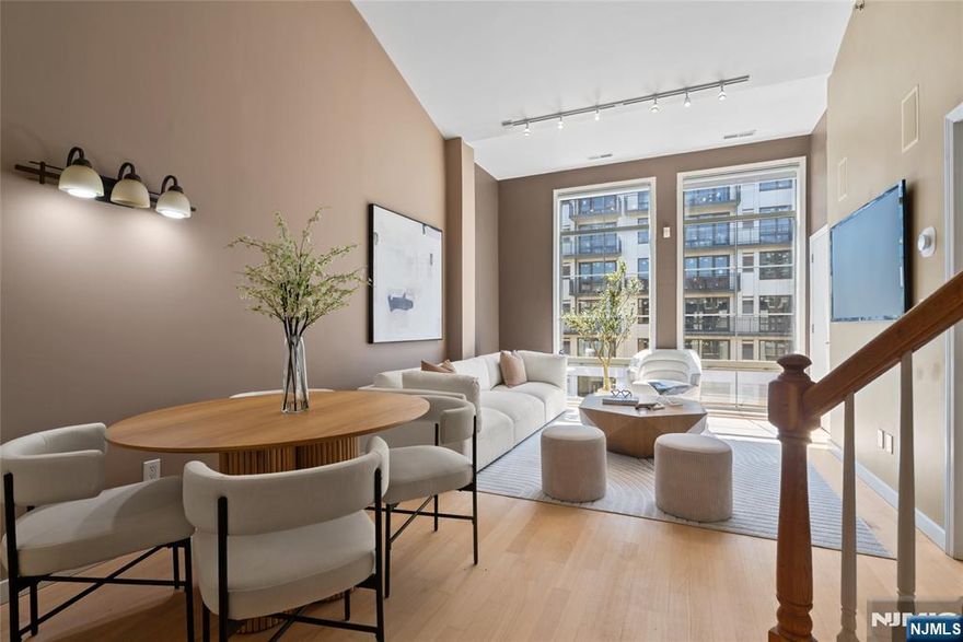 South-facing and filled with natural sunlight, this beautifully designed 2 Bedroom / 2 Bathroom duplex offers a premier lifestyle in the highly sought-after Hudson Club. Spanning 1,121 sq. ft., this bright and airy home features an open-concept kitchen with stainless steel appliances, granite countertops, and floor-to-ceiling windows that capture partial views of the NYC skyline and the Hudson River. The main level boasts soaring vaulted ceilings and a functional layout including an in-unit washer/dryer, along with a generously sized bedroom that connects to a full bath and offers ample closet space. The upper level serves as a private retreat, featuring a spacious primary bedroom with a large walk-in closet and a private en-suite bathroom. The versatile upstairs den adds incredible flexibility to the floor plan, serving as the perfect dedicated home office, guest space, or additional storage area. One assigned parking space is included with the home for your convenience. The monthly maintenance fee provides exceptional value by covering gas, water, sewer, parking, cable, and high-speed internet. Residents also enjoy access to a full suite of luxury amenities, including a 24-hour concierge, a swimming pool with a jacuzzi, a fitness center, a basketball court, a theater room, a business center, a resident lounge, and an outdoor fire pit. This unbeatable location on New Jerseyâ€™s Gold Coast offers easy access to NYC via ferry and bus, with shopping and dining favorites.