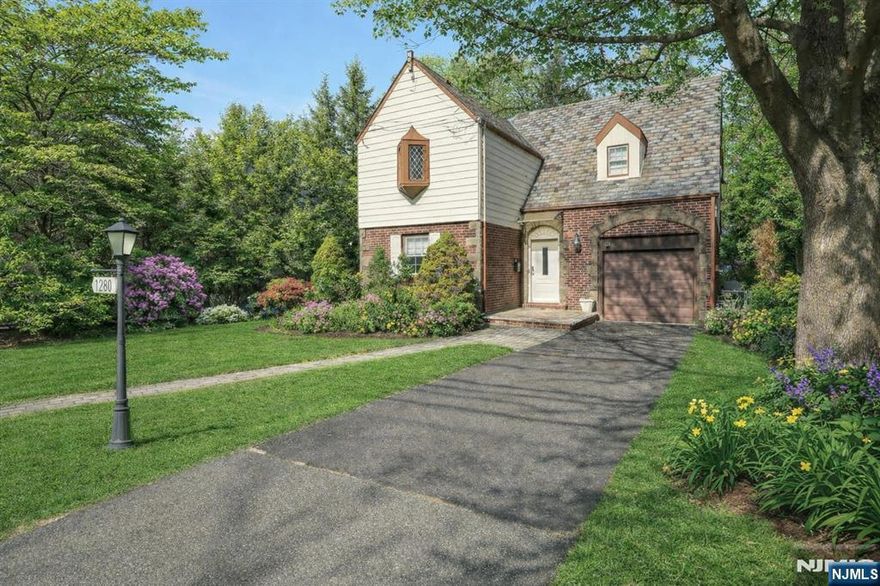 This charming Tudor Colonial is move-in ready! The bright and open main floor features a spacious dining room that flows into the living room and a sunny family room overlooking a lush backyard with mature trees and a beautifully redone deck. Upstairs offers three bedrooms, while the home includes three full bathrooms in total. The finished basement provides additional living space with a home office, gym, and full bathroom. Located in the heart of Teaneck. Centrally located to parks, transportation, shopping and houses of worship.