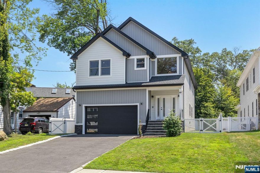 Gorgeous newer construction Colonial on a quiet, tree-lined street in one of Livingston's most desirable neighborhoods. This beautifully appointed 5BR, 5.5BA home showcases hardwood oak floors, 8-10' ceilings, custom millwork, and designer tilework throughout. The main level offers an open layout with sun-drenched living and dining areas, a family room with a sleek electric fireplace and tiled surround, and sliders that open to a private, fenced-in backyard with patio. The chef's kitchen is a standout, featuring floor-to-ceiling custom cabinetry, quartz countertops, a dramatic waterfall island, walk-in pantry, and premium Thermador appliances. Also on this floor are a first-floor en-suite, powder room, and custom mudroom with built-ins. Upstairs, the expansive primary suite boasts dual walk-in closets and a spa-like bath with soaking tub, stall shower, and double vanity. A princess suite, two additional bedrooms with shared bath, and a full laundry room complete the second floor. The finished basement includes a spacious rec/media room, full bath, and ample storage. Additional features include custom blinds throughout, a full sprinkler system, a whole-home water treatment system, and the balance of a 10-year builder warranty. Prime location near top-rated schools, houses of worship, parks, shopping, and NYC transportation.